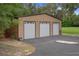 Three-car garage exterior featuring multiple garage doors, ample parking, and durable metal siding at 22063 Lake Lindsey Rd, Brooksville, FL 34601