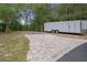 Exterior shot of a paved parking area ideal for RV parking, featuring brick pavers and gravel space at 22063 Lake Lindsey Rd, Brooksville, FL 34601