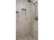 Close-up of tiled shower with niche and shower head at 22063 Lake Lindsey Rd, Brooksville, FL 34601