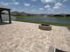 Spacious backyard patio featuring a fire pit and a scenic lake view at 2410 Mizner Bay Ave, Bradenton, FL 34208