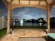 Scenic backyard view from the covered patio showing a pond and fountain at night at 2410 Mizner Bay Ave, Bradenton, FL 34208