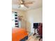 Comfortable bedroom with bright orange bedspread, ceiling fan, and wood-look flooring at 2410 Mizner Bay Ave, Bradenton, FL 34208