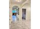 Hallway featuring decorative archways leading to the living room and laundry room at 2410 Mizner Bay Ave, Bradenton, FL 34208