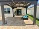 Covered patio with brick pavers and comfortable seating area overlooking backyard at 2410 Mizner Bay Ave, Bradenton, FL 34208