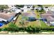 Overhead shot showcasing the house, surrounding properties, and lush greenery bordering a canal at 2420 16Th W St, Palmetto, FL 34221
