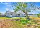 Exterior view of the home and back patio, framed by a mature tree and grassy lawn at 2420 16Th W St, Palmetto, FL 34221