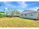 Backyard view of the home and surrounding foliage, with a large tree providing ample shade at 2420 16Th W St, Palmetto, FL 34221