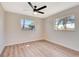 Bright bedroom featuring wood-look floors, a ceiling fan, and two windows offering natural light at 2420 16Th W St, Palmetto, FL 34221