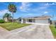 Charming single-story home with a light gray exterior, lush green lawn, and a spacious two-car garage at 2420 16Th W St, Palmetto, FL 34221