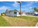 Single-story home with a gray exterior and a large front yard featuring mature trees and a long driveway at 2420 16Th W St, Palmetto, FL 34221