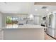 The kitchen island boasts quartz countertops, modern appliances, and white cabinets, with easy access to the backyard at 2420 16Th W St, Palmetto, FL 34221