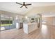 Open concept kitchen featuring modern appliances, white cabinets, an island, and a sliding glass door to the backyard at 2420 16Th W St, Palmetto, FL 34221