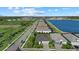 An aerial view of the neighborhood, showcasing homes along a street by a lake at 26000 Seastone Dr, Englewood, FL 34223
