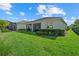 Well-maintained backyard with green lawn, mature shrubs, and screened-in porch, perfect for relaxation at 26000 Seastone Dr, Englewood, FL 34223