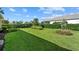 Expansive backyard featuring lush lawn, manicured landscaping, and privacy hedges at 26000 Seastone Dr, Englewood, FL 34223