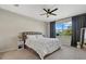 Bright bedroom with a comfortable bed, ceiling fan, and natural light at 26000 Seastone Dr, Englewood, FL 34223