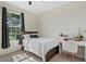 Sunlit bedroom featuring a comfortable bed, study desk, and large bright window at 26000 Seastone Dr, Englewood, FL 34223