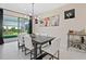 Bright dining room features modern chandelier, table with seating, and sliding glass doors to the outdoor space at 26000 Seastone Dr, Englewood, FL 34223