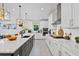 Spacious kitchen features white cabinets, a center island with quartz countertops and stainless appliances at 26000 Seastone Dr, Englewood, FL 34223