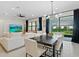 Bright living room with modern furniture, a large TV, and sliding glass doors to the outdoor area at 26000 Seastone Dr, Englewood, FL 34223