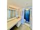 Bathroom with updated vanity and shower with blue curtain at 2675 Gulf Of Mexico Dr # 203, Longboat Key, FL 34228