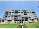 Exterior view of building with balconies, landscaping, and lush grass at 2675 Gulf Of Mexico Dr # 203, Longboat Key, FL 34228