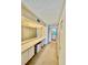 Hallway leading to bathroom and closets with lighted vanity at 2675 Gulf Of Mexico Dr # 203, Longboat Key, FL 34228