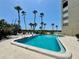 Sparkling community pool surrounded by palm trees offering a relaxing oasis at 2675 Gulf Of Mexico Dr # 203, Longboat Key, FL 34228