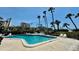 Inviting community pool with lounge chairs, palm trees, and lush tropical landscaping at 2675 Gulf Of Mexico Dr # 203, Longboat Key, FL 34228