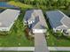 Aerial view of beautiful home with manicured lawn, brick paver driveway, and screened-in lanai, surrounded by lush landscaping at 2794 Butterfly Jasmine Trl, Sarasota, FL 34240