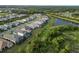 An aerial view of a green residential neighborhood with a pond and lush landscaping at 2794 Butterfly Jasmine Trl, Sarasota, FL 34240