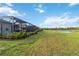 Expansive backyard offers a blend of manicured lawn and natural surroundings, plus water view at 2794 Butterfly Jasmine Trl, Sarasota, FL 34240