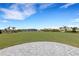 Expansive backyard view with lush green grass, landscaping, and serene lake views at 2794 Butterfly Jasmine Trl, Sarasota, FL 34240