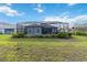Spacious backyard featuring a screened-in patio area and verdant green lawn at 2794 Butterfly Jasmine Trl, Sarasota, FL 34240
