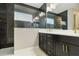 Modern bathroom featuring dual sinks, black cabinetry, gold hardware, and a glass-enclosed shower with black tile at 2794 Butterfly Jasmine Trl, Sarasota, FL 34240