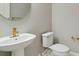Elegant powder room with a pedestal sink, gold fixtures, and a round mirror at 2794 Butterfly Jasmine Trl, Sarasota, FL 34240