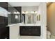 Modern bathroom with double vanity, black cabinets, and black tiled shower at 2794 Butterfly Jasmine Trl, Sarasota, FL 34240