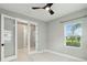Bright bedroom with marble floors, neutral paint, large window, and a stylish ceiling fan at 2794 Butterfly Jasmine Trl, Sarasota, FL 34240
