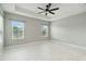 Bright and airy primary bedroom featuring tile floors, a ceiling fan, and two large windows at 2794 Butterfly Jasmine Trl, Sarasota, FL 34240