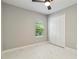Bright bedroom featuring neutral walls, tiled floor, ceiling fan, and a closet with double doors at 2794 Butterfly Jasmine Trl, Sarasota, FL 34240