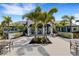 Beautiful clubhouse exterior with palm trees, outdoor seating, and a welcoming entrance at 2794 Butterfly Jasmine Trl, Sarasota, FL 34240