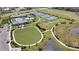 Aerial view of community green space, tennis courts, and pool, creating a vibrant recreational area at 2794 Butterfly Jasmine Trl, Sarasota, FL 34240
