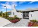 A beautifully landscaped walkway leading to an ornate metal gate and pristine white clubhouse exterior at 2794 Butterfly Jasmine Trl, Sarasota, FL 34240