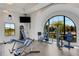 Well-lit gym with an arched window and contemporary fitness machines at 2794 Butterfly Jasmine Trl, Sarasota, FL 34240