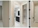 Hallway view showing access to the bathroom, bedroom, and a closet with classic black door hardware at 2794 Butterfly Jasmine Trl, Sarasota, FL 34240