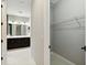 Hallway view showcasing the bathroom with double vanity and walk-in closet with wire shelving at 2794 Butterfly Jasmine Trl, Sarasota, FL 34240