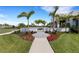 Beautiful home exterior with lush landscaping, flowers, and a well-manicured lawn at 2794 Butterfly Jasmine Trl, Sarasota, FL 34240