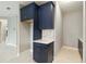 A kitchen detail featuring blue cabinets with marble backsplash and modern white countertops at 2794 Butterfly Jasmine Trl, Sarasota, FL 34240