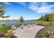 Scenic lakeside view showcasing comfortable white Adirondack chairs on a concrete pad at 2794 Butterfly Jasmine Trl, Sarasota, FL 34240
