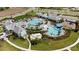 Aerial view of a resort-style community pool with a splashpad, poolside seating, and manicured landscaping at 2794 Butterfly Jasmine Trl, Sarasota, FL 34240